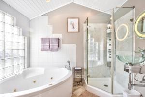 een witte badkamer met een bad en een douche bij Lakefront Oasis with Skylights & Covered Boat Slip For Extra Adventure in Laguna Beach +82 foto's