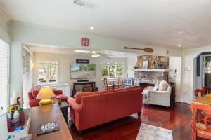 een woonkamer met rode meubels en een open haard bij Lakefront Oasis with Skylights & Covered Boat Slip For Extra Adventure in Laguna Beach