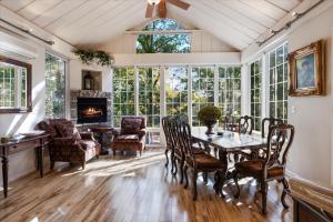 a dining room with a table and chairs and a fireplace at Six Suites with Hot Tubs, Private Jacuzzi Baths, Wooded Garden and Lake Access with Boat Slip in Damsel