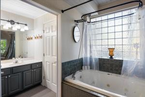 a bathroom with a tub and a sink at Six Suites with Hot Tubs, Private Jacuzzi Baths, Wooded Garden and Lake Access with Boat Slip in Damsel +90 photos