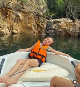 a young girl laying on a raft in the water at MesaVibes in Colinas Do Sul