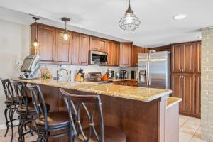 una cucina con armadi in legno e bancone con sgabelli da bar di Lake Life: Amazing Weekday Specials! Dock, Swim Mat, Cove Water a Rocky Mount