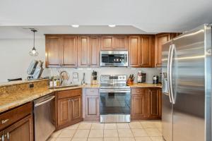 una cucina con mobili in legno e un frigorifero in acciaio inossidabile di Lake Life: Amazing Weekday Specials! Dock, Swim Mat, Cove Water a Rocky Mount