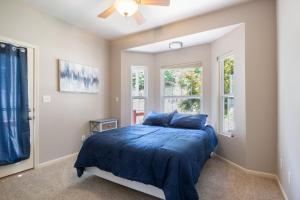 a bedroom with a bed with blue sheets and a window at Lux Lakehouse w/ 2 Living Areas, Screened Porch & Dock Access at 22MM in Damsel