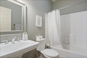 a white bathroom with a toilet and a sink at Lux Lakehouse w/ 2 Living Areas, Screened Porch & Dock Access at 22MM in Damsel +42 photos