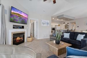 a living room with a couch and a fireplace at Main Channel Views, Screened Porch, Pool & Boat Slip in Lake Ozark