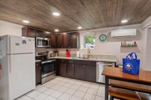 eine Küche mit einem weißen Kühlschrank und einer Holzdecke in der Unterkunft Lakefront Fishing Retreat w/ Dock, Hot Tub & Deck Views in Sunrise Beach + 39 Fotos