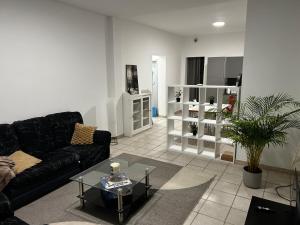 a living room with a black couch and a table at Grâce in Grâce-Hollogne