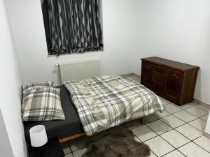 a small bedroom with a bed and a dresser at Grâce in Grâce-Hollogne