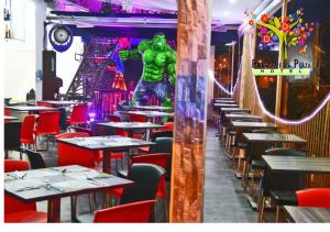 a restaurant with tables and a hulk statue in the background at Hotel Primavera Plaza in Melgar