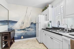 a kitchen with a large painting of a sailboat on the wall at Sailors Cabin - Prime Downtown Key West Spot - Walk to Duval in Key West