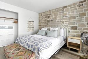 een slaapkamer met een groot bed en een stenen muur bij Hot Tub, Main Channel Views, Great Outdoor Spaces, Blackstone in Sunrise Beach