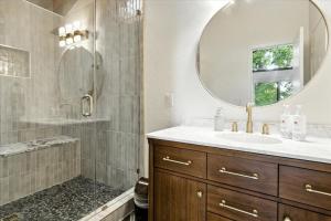 een badkamer met douche, wastafel en spiegel bij Hot Tub, Main Channel Views, Great Outdoor Spaces, Blackstone in Sunrise Beach +44 foto's