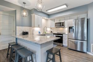 a kitchen with a large island with bar stools at Walk to The Strip! Great Cove Water for Lake Fun in Lake Ozark