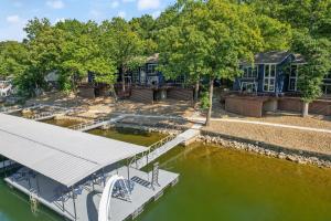 a dock with a boat in the water at Walk to The Strip! Great Cove Water for Lake Fun in Lake Ozark