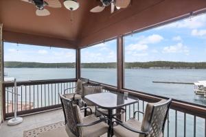 a balcony with a table and chairs and a view of the water at Poolside Condo with Amazing Lake Views & Design in Damsel