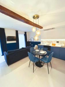 un soggiorno con tavolo e sedie blu di Lemon Suites Santander a Santander