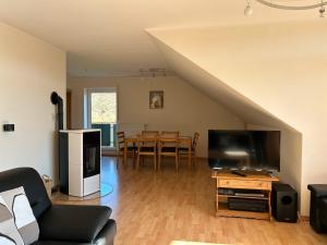 a living room with a couch and a flat screen tv at Ferienwohnung Moos-Hochsauerland in Wiemeringhausen