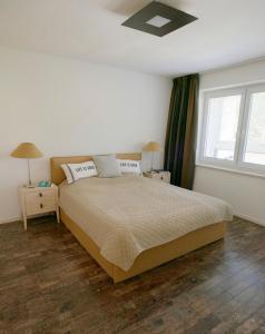 a bedroom with a bed with two night stands and a window at Spacious Apartment,Balcony&Garage in Bratislava