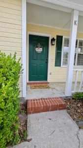 a green door on a house with a brick stoop at 5 Minutes to VSU- Sleeps 5 King Bed 2 baths in Valdosta
