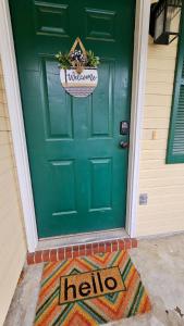 a green door with a hello sign on it at 5 Minutes to VSU- Sleeps 5 King Bed 2 baths in Valdosta +27 photos