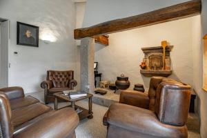 a living room with leather furniture and a stone fireplace at Private Villa T8 - Casa Da Bra Viana Do Castelo in Viana do Castelo