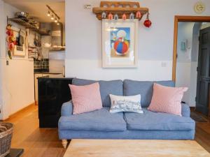 a blue couch in a living room with pink pillows at Seaside in Lyme Regis