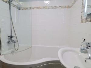 a white bathroom with a shower and a sink at Seaside in Lyme Regis +22 photos
