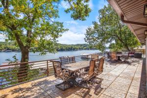 a table and chairs on a deck next to the water at Spacious, Quiet & Great Cove, Nearby Attractions, Private Dock, Fireplace, Expansive Deck in Rocky Mount