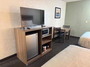 a hotel room with a flat screen tv and a desk at Quality Inn in West Des Moines