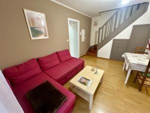 a living room with a red couch and a table at Duplex appartement in Bayeux in Bayeux