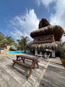 ein Picknicktisch und eine Strohhütte mit einem Pool in der Unterkunft La Playita Casa de Playa con Piscina Jacuzzi y Acesso directo al Mar in Los Córdobas