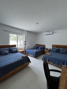 ein Schlafzimmer mit zwei Betten und einem Fenster in der Unterkunft La Playita Casa de Playa con Piscina Jacuzzi y Acesso directo al Mar in Los Córdobas