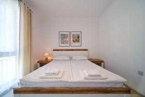 バルチクにあるApartment Emma complex Carpe Diem Balchikのベッドとタオル2枚のある寝室