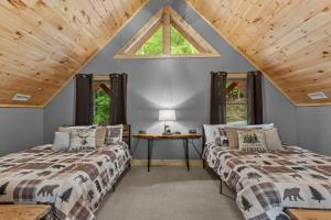 two beds in a attic room with a window at Bear Necessities in Beech Mountain
