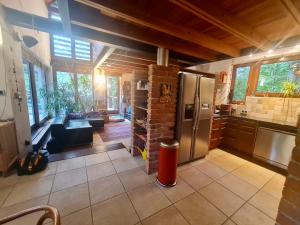 a kitchen and living room with a stainless steel refrigerator at Calderus house Dobogókő in Pilisszentkereszt