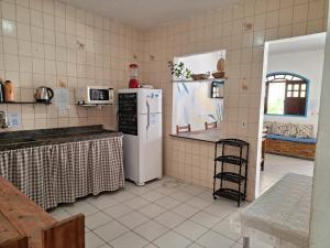 a kitchen with a white refrigerator and a counter at Odoyá Casa Hostel in Arraial d'Ajuda +53 photos