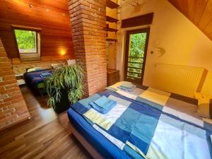 a bedroom with two beds and a brick wall at Calderus house Dobogókő in Pilisszentkereszt