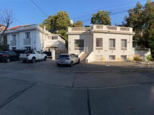 a white house with two cars parked in a parking lot at Home Estudio 3 in Santiago