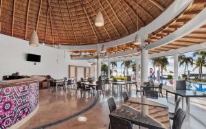 a restaurant with tables and chairs and a pool at Casa Oasis B-Nayar Gated, Beach Club, Free Shuttle in Cruz de Huanacaxtle