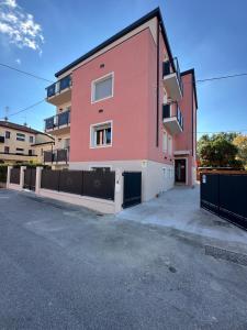 a pink building with a fence in front of it at Casa Tintoretto The Charm of Venice in 15 minutes! in Venice