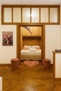 una camera da letto con un letto con testiera in legno di Colosseum Window Rome - Central Historical Apartment a Roma