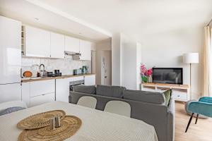 a living room with a couch and a kitchen at Friendly and spacious apartment in Créteil ! in Créteil