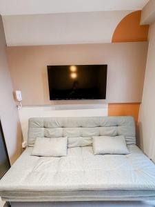 uma sala de estar com um sofá e uma televisão na parede em !Novinho! Apê Elamor - Brooklin - SP em São Paulo