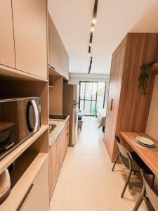 uma cozinha com uma mesa de jantar e um micro-ondas em !Novinho! Apê Elamor - Brooklin - SP em São Paulo
