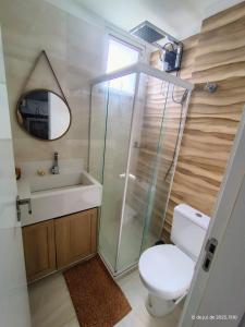 a bathroom with a toilet and a sink and a mirror at Cantinho Real in Ilhéus
