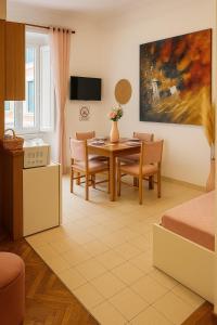 un soggiorno con tavolo da pranzo e sedie di Colosseum Window Rome - Central Historical Apartment a Roma