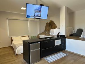 uma sala de estar com uma TV na parede em Loft MarSol em Piúma