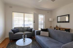 a living room with a couch and a table at Gem Apartment 4 - Courtyard I Beach I Wifi I Cafes in Glenelg