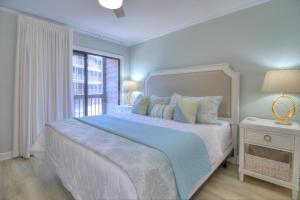 a white bedroom with a large bed and a window at Tilghman Beach & Racquet Club - 114 in Myrtle Beach +41 photos